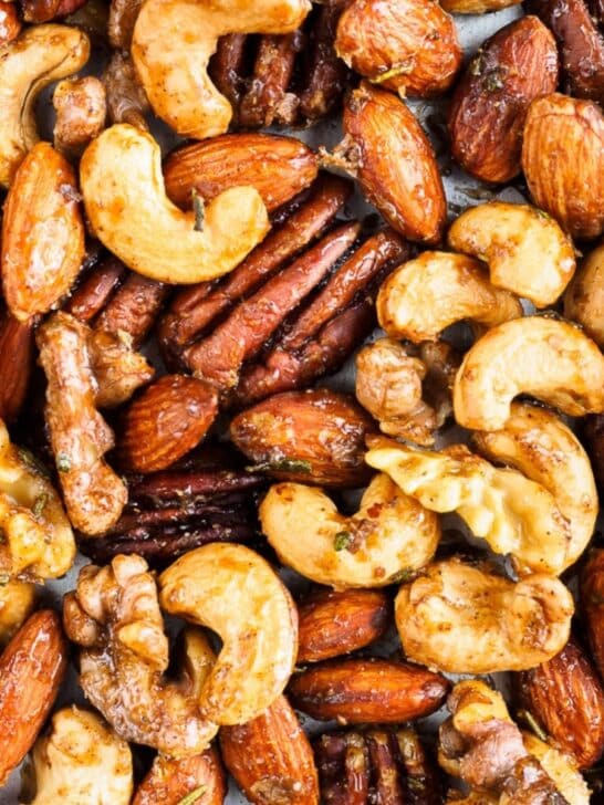 Spiced cashews, almonds, walnuts and pecans on baking sheet.