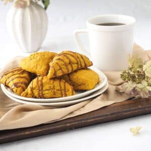 Pumpkin scones drizzled with espresso on dish.