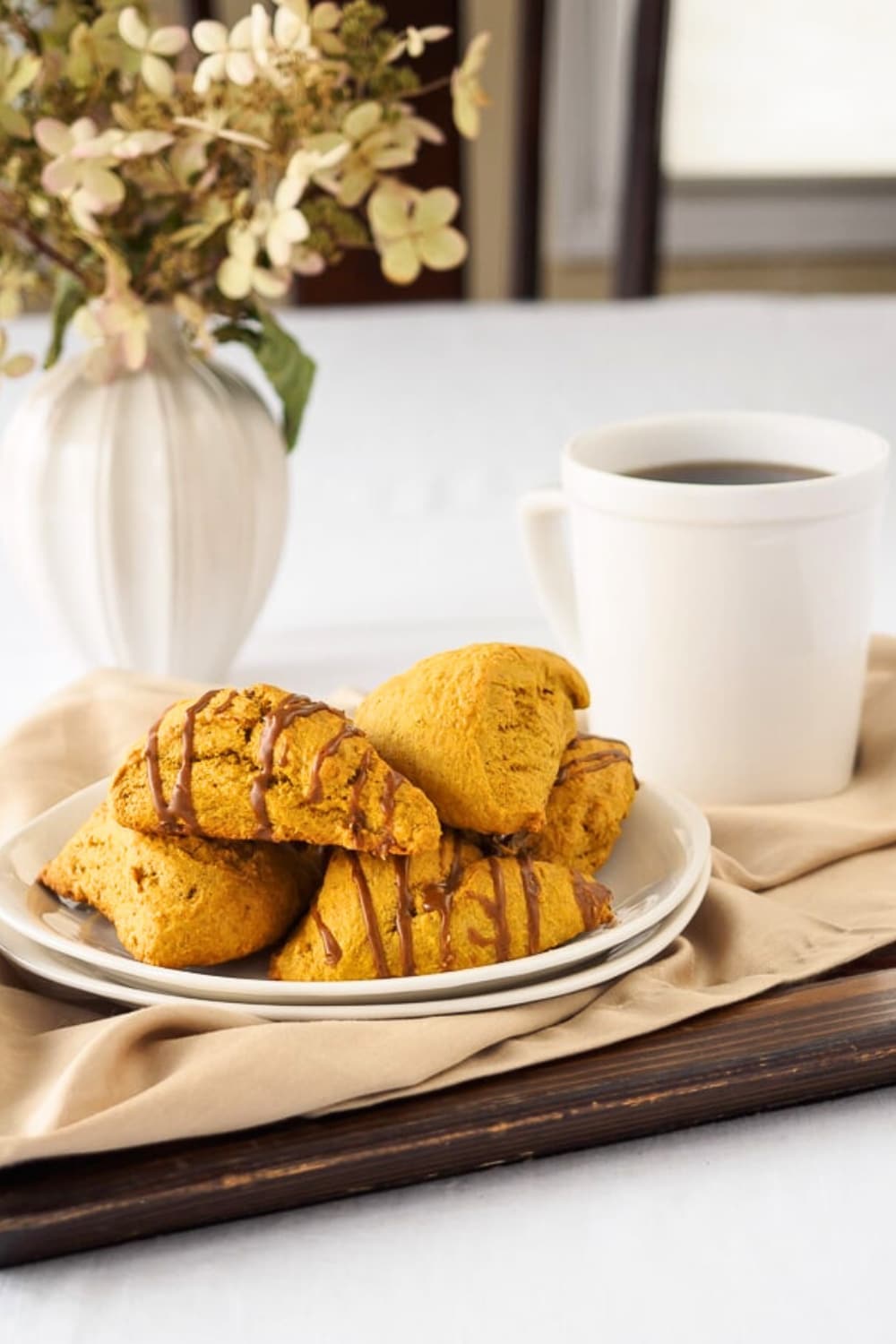 Spiced pumpkin scones on dish served with coffee.