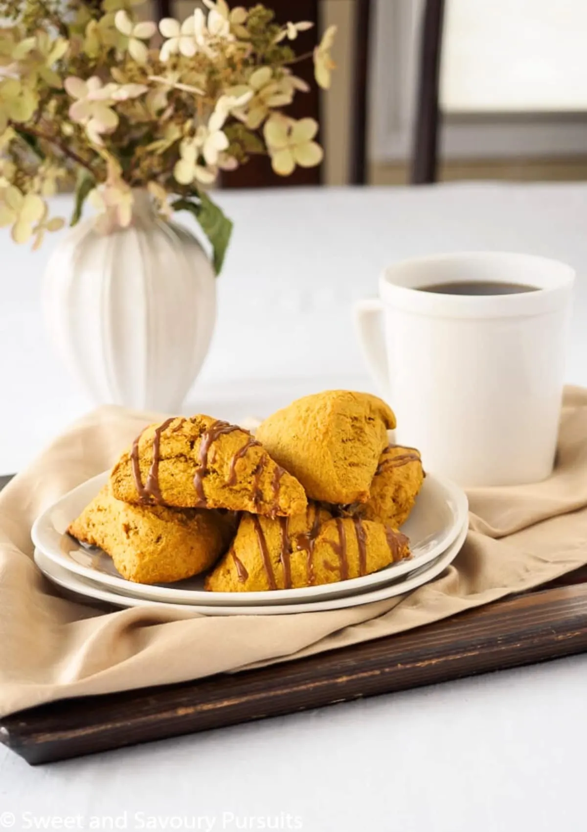 Dish of pumpkin scones served with a cup of coffee.