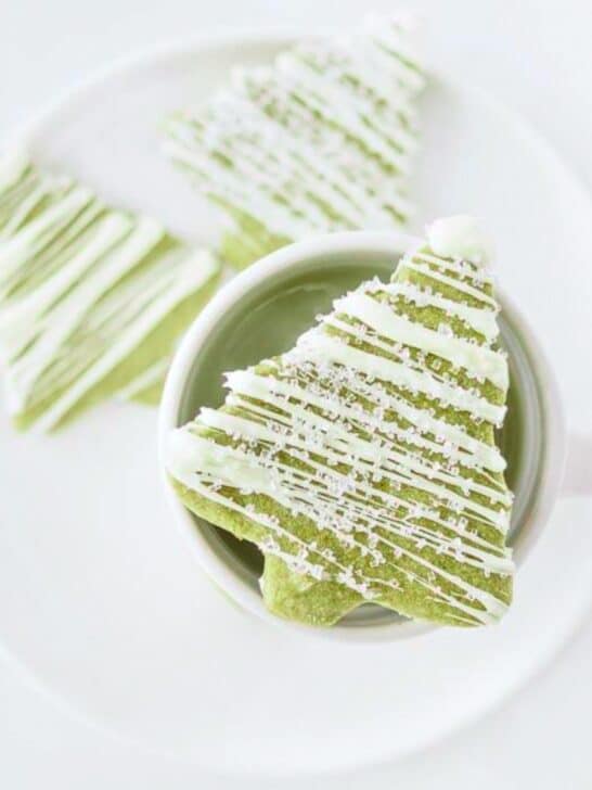 Matcha sugar cookies on plate with a cup of matcha latte.