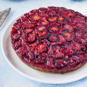 Plum upside-down cake on white plate.