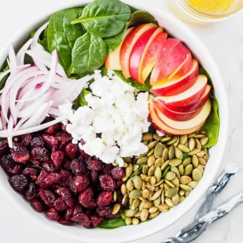 Top view of spinach, apple and cranberry salad.