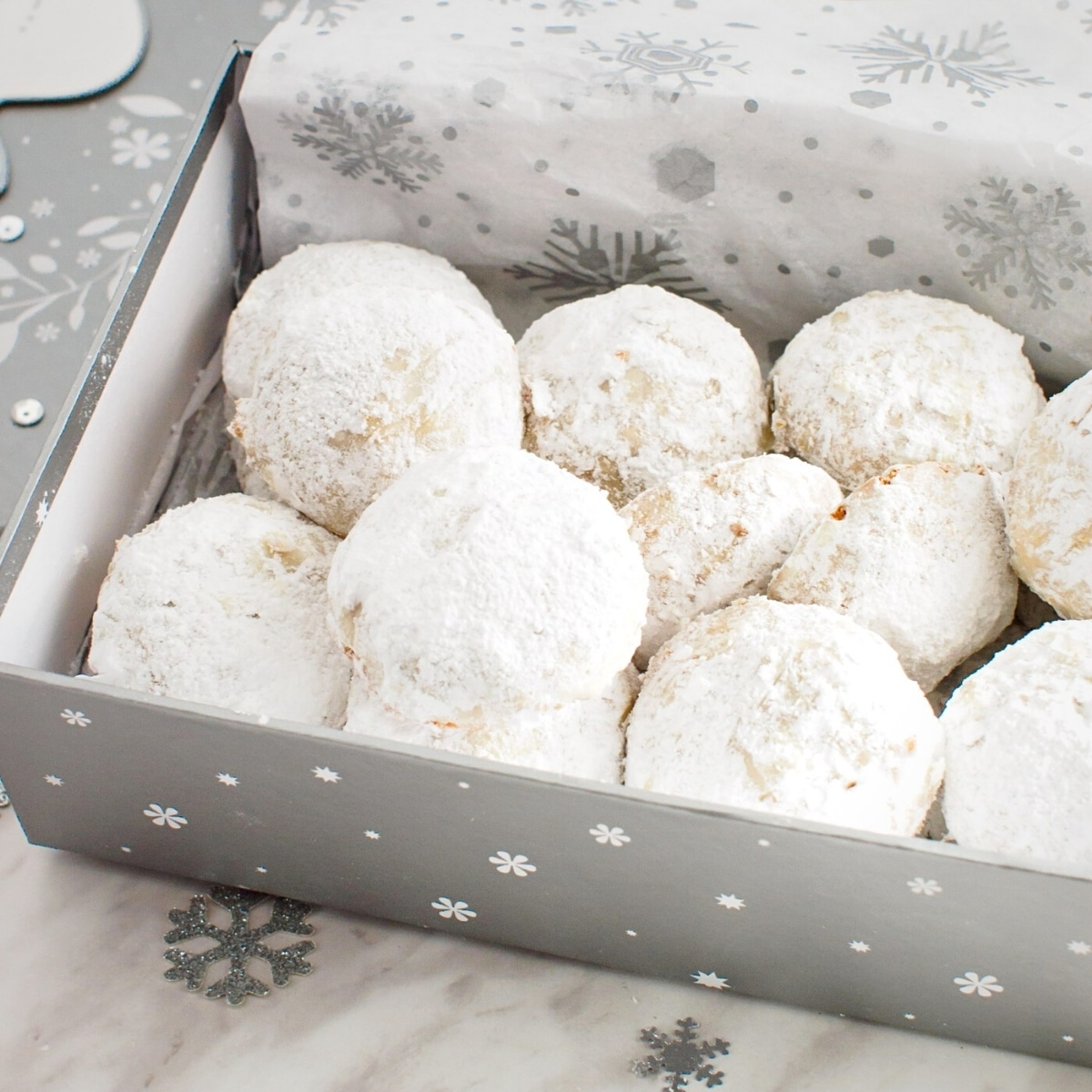 Almond cookies covered with powdered sugar in a gift box.