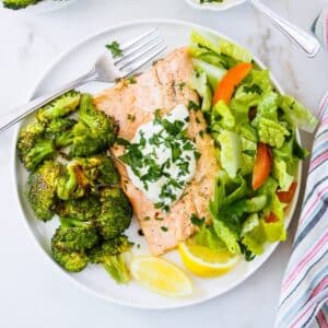Plate of Rainbow Trout fillets with roasted broccoli and salad.