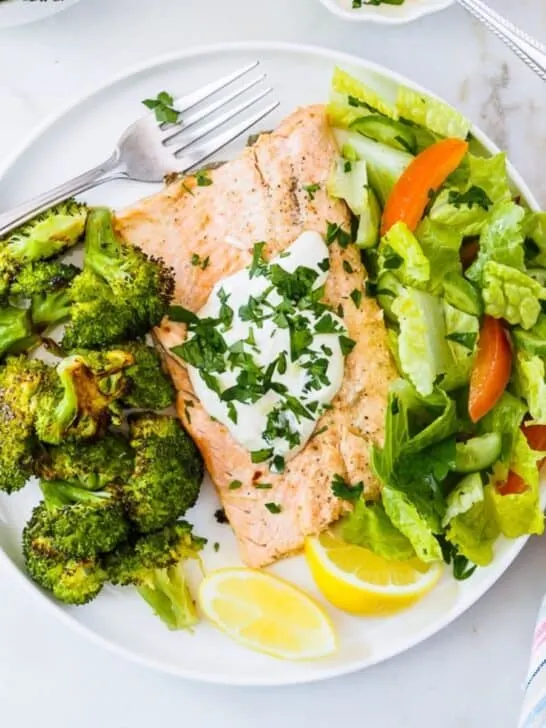 Plate of Rainbow Trout fillets with roasted broccoli and salad.