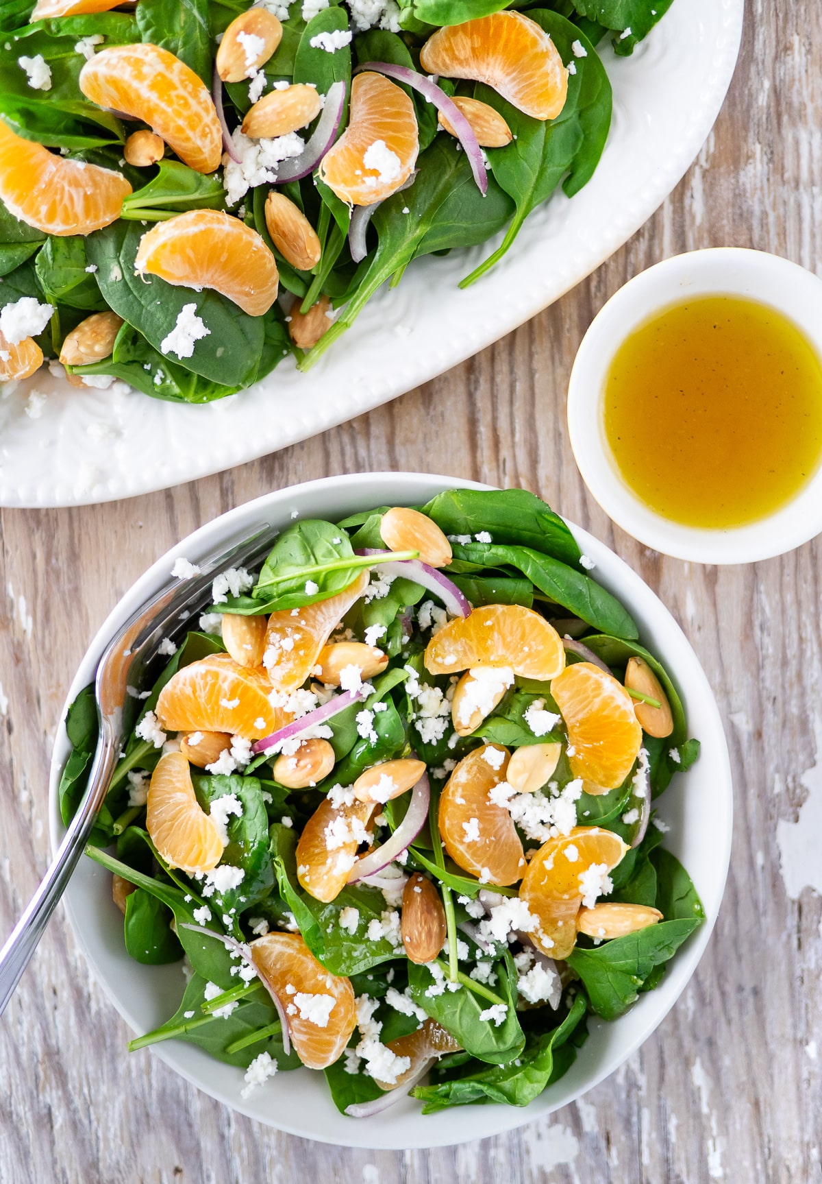 Bowl of spinach and clementine salad.