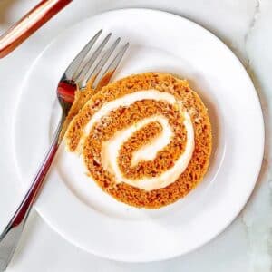 Slice of pumpkin roll cake on dish.