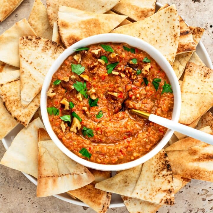 Bowl of Mhammara served with Pita chips.