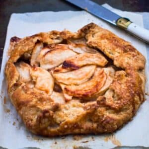 Rustic apple galettes on baking sheet.