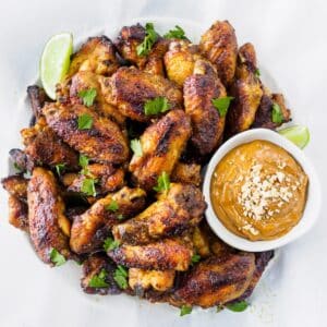 Plate of Thai flavored chicken wings served with peanut sauce.