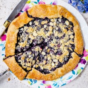 Rustic blueberry galette topped with sliced almonds and crumbled marzipan.