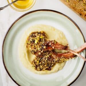 Plate of dukkah-crusted lamb chops served over cauliflower potato purée.
