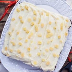 One-layer gingerbread cake with cream cheese frosting on platter.
