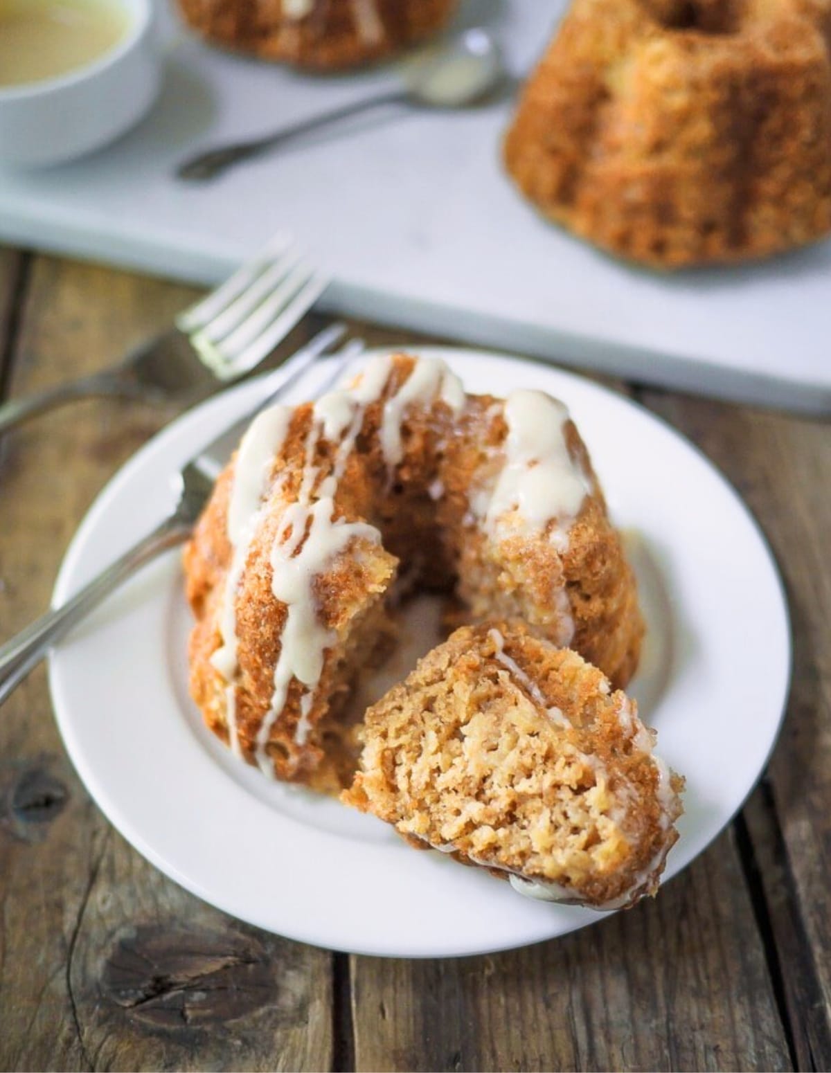 Mini apple bundt cake on small white dish.