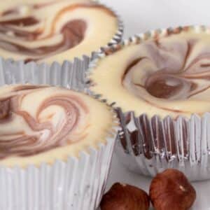 Mini Nutella swirl cheesecakes made in foil cups.
