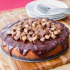 Peanut butter and chocolate cheesecake on wooden board.