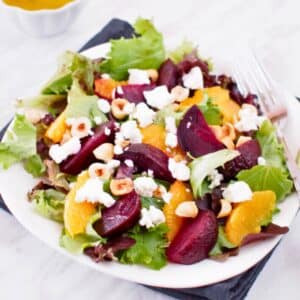 Plate of roasted beet and orange salad served with citrus vinaigrette.