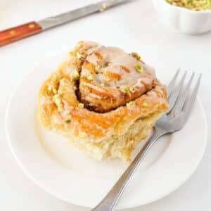 Tahini and pistachio cinnamon roll on small plate.