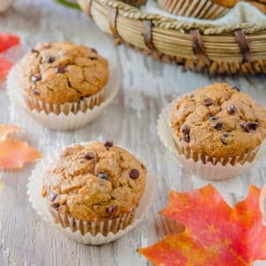 Pumpkin chocolate chip muffins on wood board.
